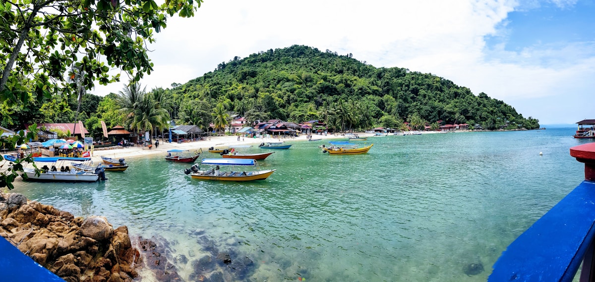 Speedboats moored in the bay at Pulau Perhentian Kecil with jungle hills behind, Terengganu, Malaysia