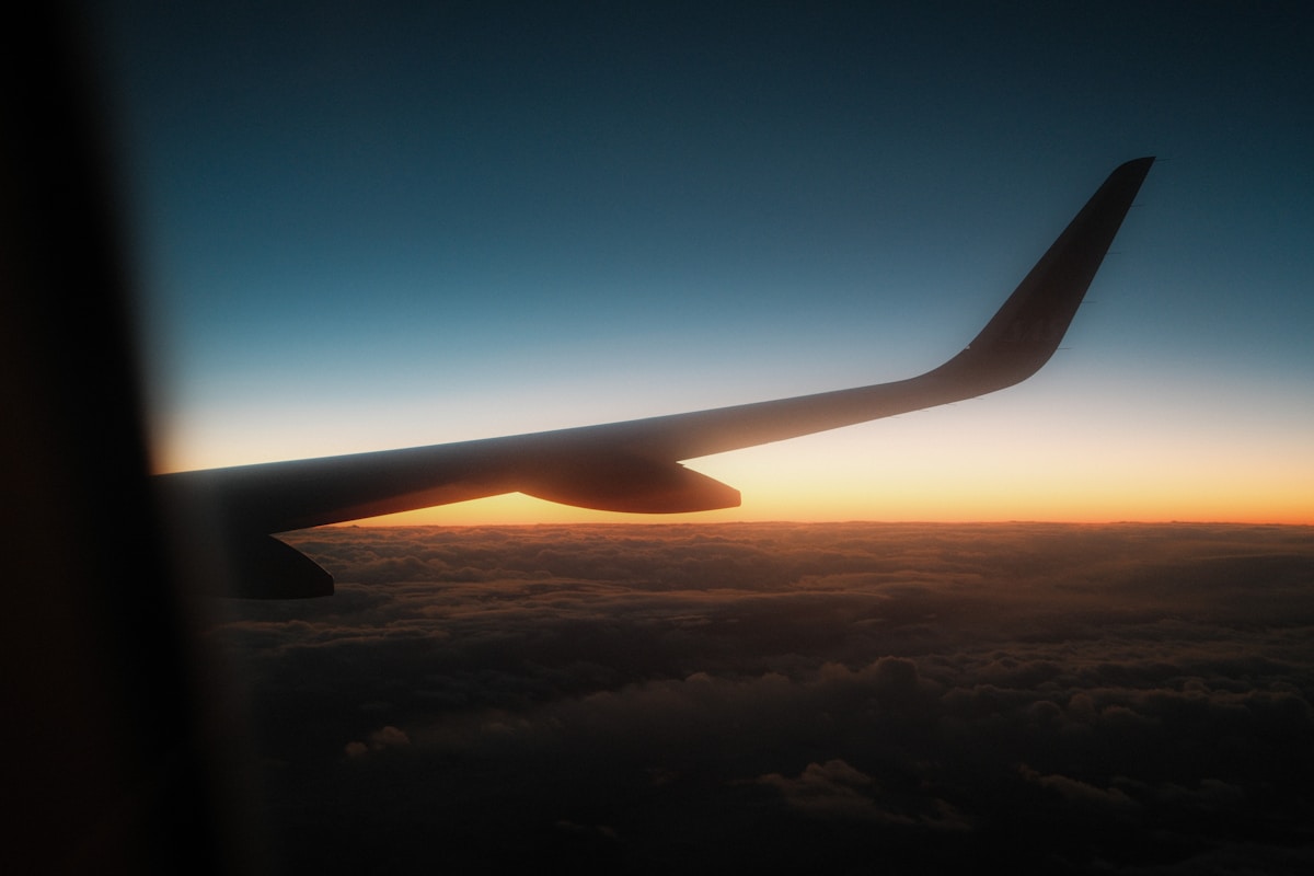 Aircraft wing over a sunset sky, flights to Malaysia