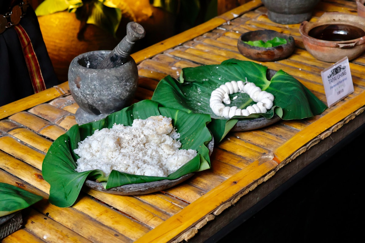 Rice served on banana leaves with stone mortar and pestle at cultural village, Kota Kinabalu, Malaysia