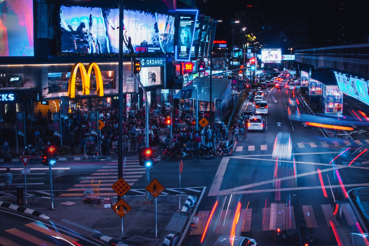 Pedestrians crossing the busy Bukit Bintang intersection at night, Kuala Lumpur