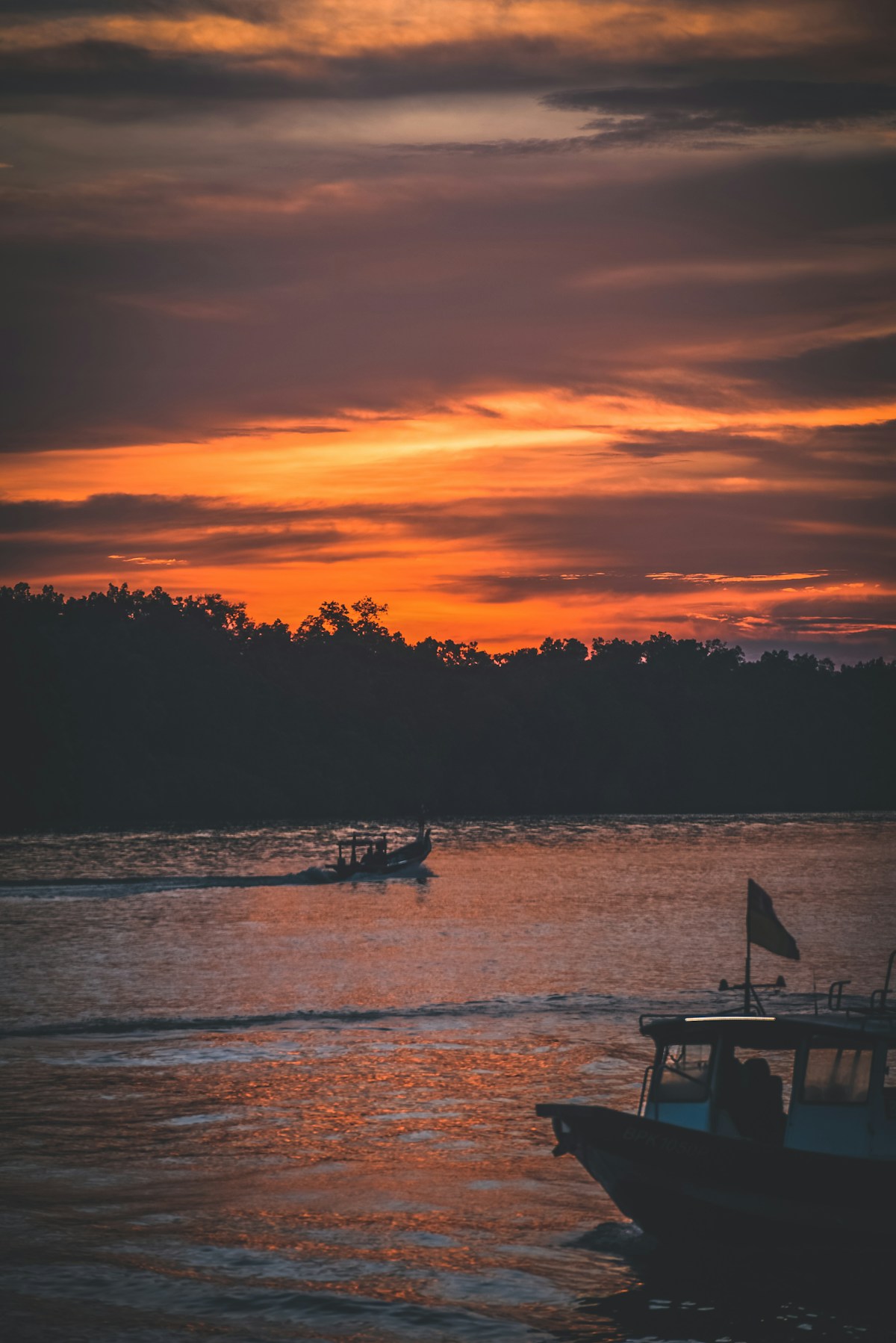 Sunset reflections on water with boats, Kuala Selangor, Selangor, Malaysia
