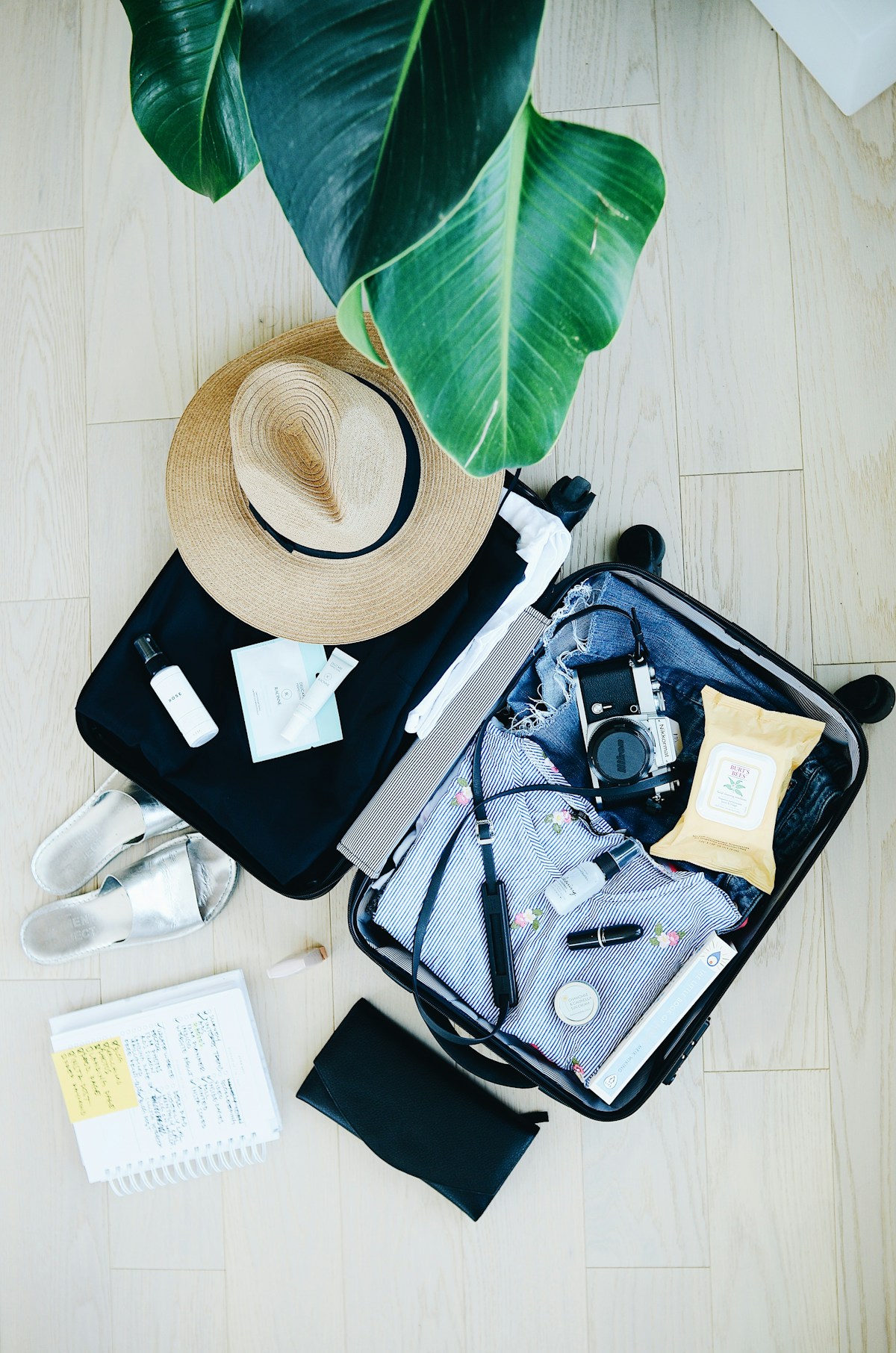 Open suitcase with travel essentials laid out, packing for a tropical trip