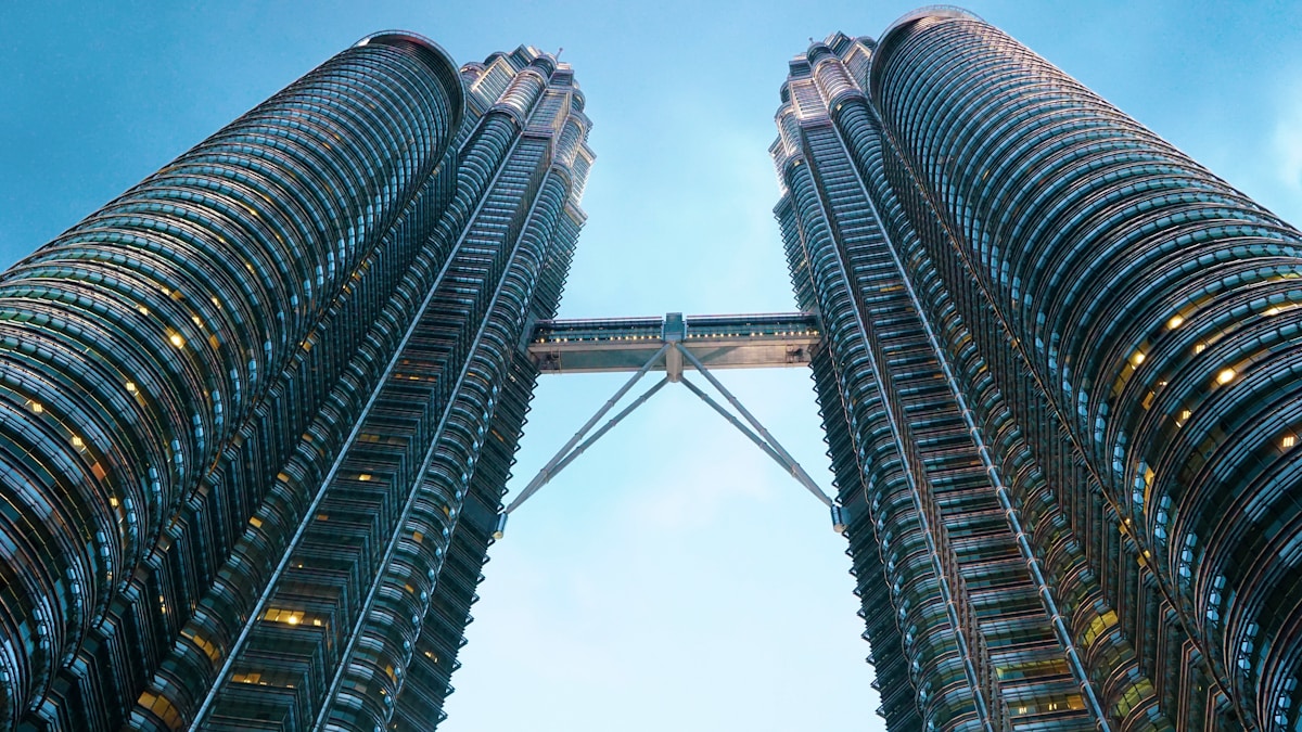 Petronas Twin Towers in Kuala Lumpur representing Malaysia alongside tropical beaches