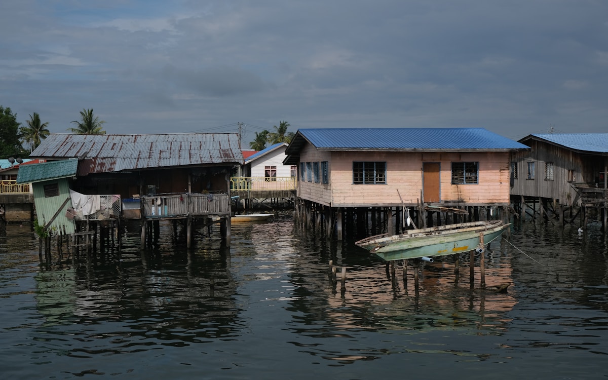 A boat next to a house on water, Miri, Sarawak, Malaysia