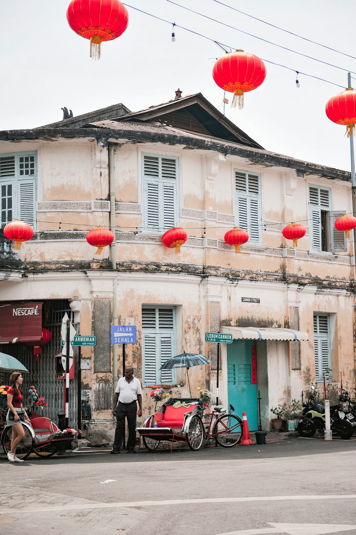 Heritage shophouse with red lanterns and trishaw, Georgetown, Penang, Malaysia