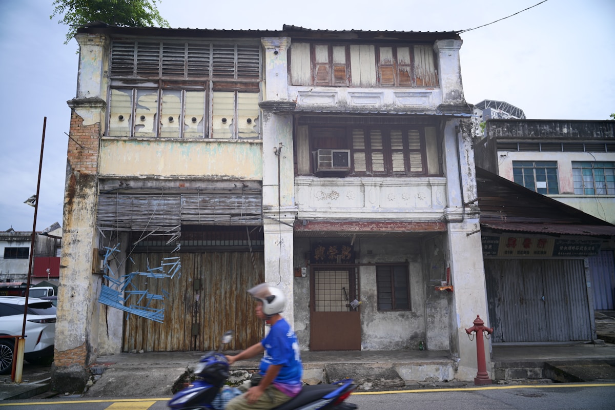 Weathered Peranakan-era shophouses on a heritage street in Malaysia